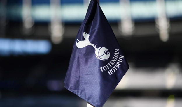  A navy blue Tottenham Hotspur flag featuring the club’s iconic cockerel logo in white, waving in a stadium.