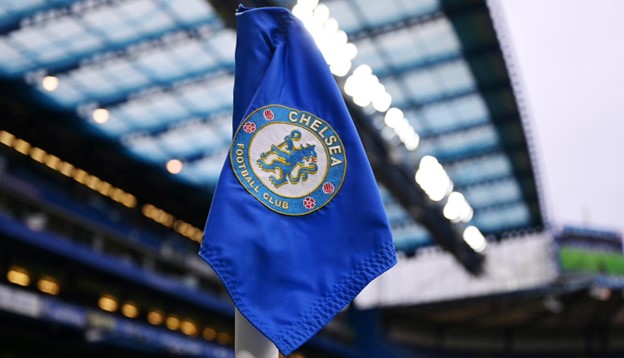 A Chelsea Football Club flag with the team’s logo, waving in the air at a stadium.